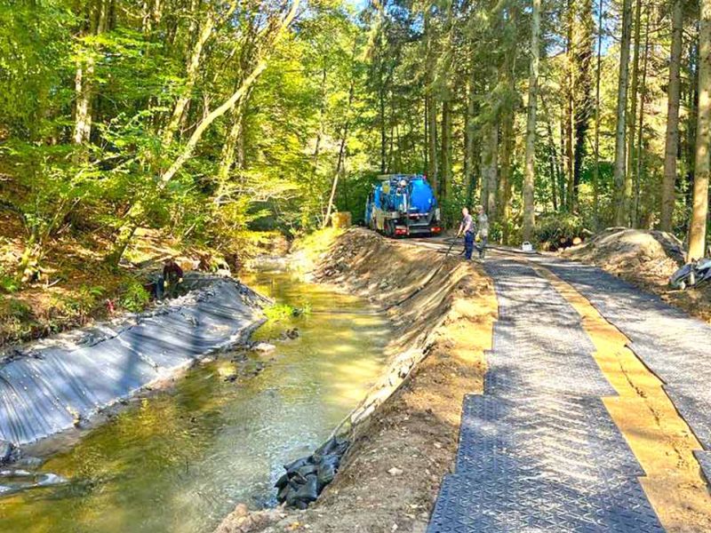 Fahrplatten zum Schutz des Waldboden während Baumfällungen am Bachlauf