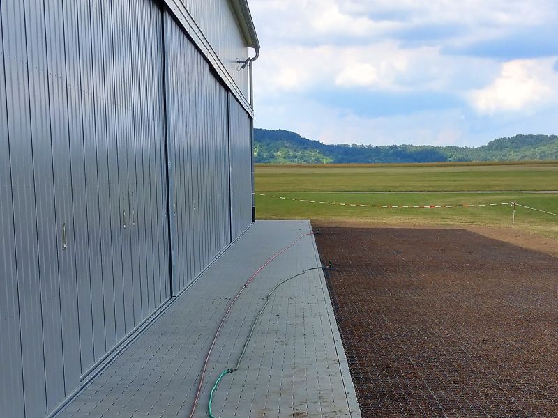 Immer auf der Höhe – Bodengitter BG50 zur Befestigung zweier Rasenflächen vor einer Flugzeughalle