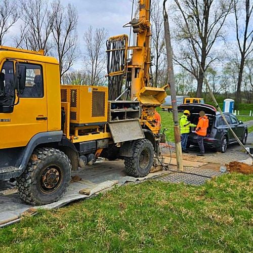 Fahrplatten zum Bodenschutz in der Bohrtechnik. Darauf stehen ein Bohrfahrzeug und Personen. Im Hintergrund sind Bäume zu sehen.