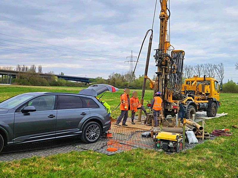 Bohrfahrzeug und Arbeiter im Einsatz auf Bodenschutzplatten bei Erdbohrung