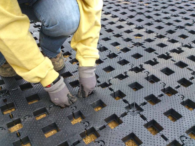 Zwei Hände drücken die Rasengittersteine an den Verbindungskanten zusammen.