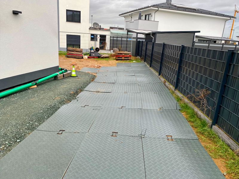 Verlegte Kunststoffplatten bilden einen stabilen und sauberen Baustellenzugang.