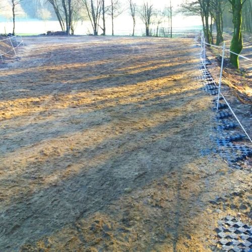 Befestigter Freilaufbereich eines Pferdepaddocks mit strukturierter Bodenbefestigung.