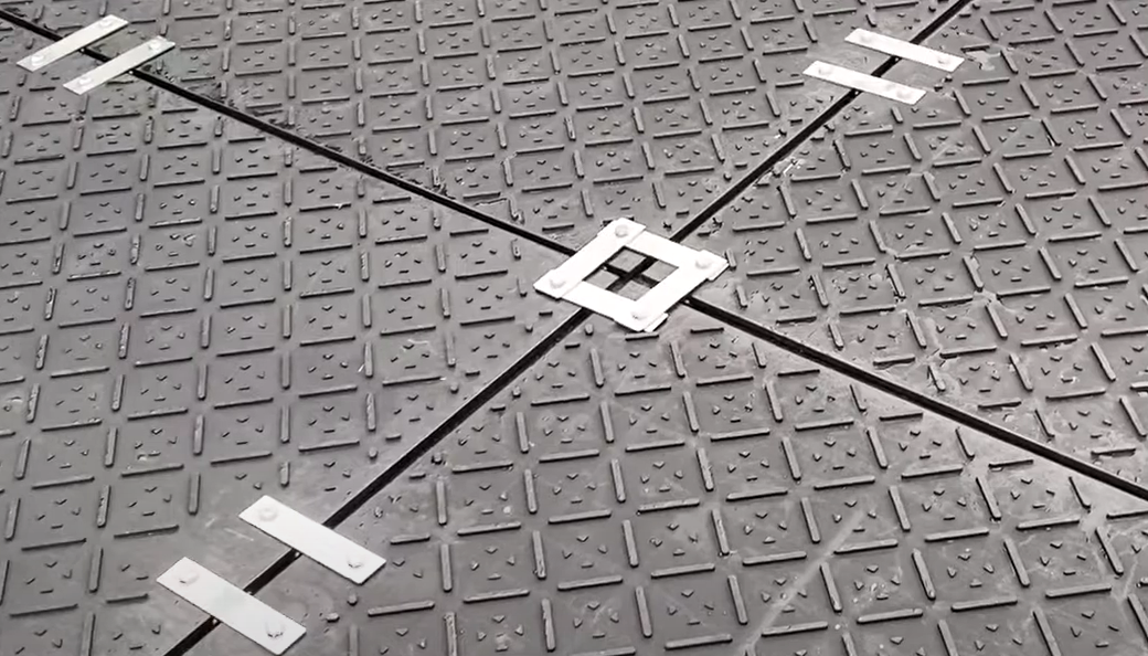 Versetzte Verlegung von Kunststoffplatten im Halbverband zur Stabilisierung eines Flächenverbundes für temporäre Fahrspuren