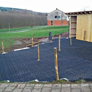Neu verlegte Bodengitter BG30/BG50 auf einer Rasenfläche neben einem Schuppen aus Holz