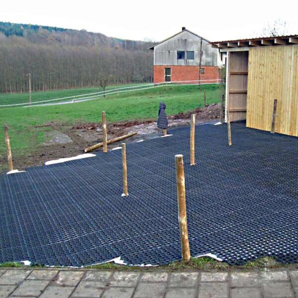 Neu verlegte Bodengitter BG30/BG50 auf einer Rasenfläche neben einem Schuppen aus Holz