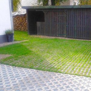 Befestigung der Rasenfläche vor einem Gartenhaus mit dem Rasengitterstein RGS35 aus Kunststoff