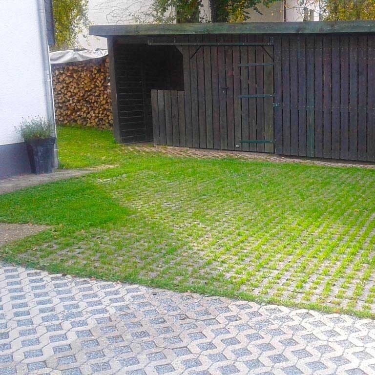 Befestigung der Rasenfläche vor einem Gartenhaus mit dem Rasengitterstein RGS35 aus Kunststoff