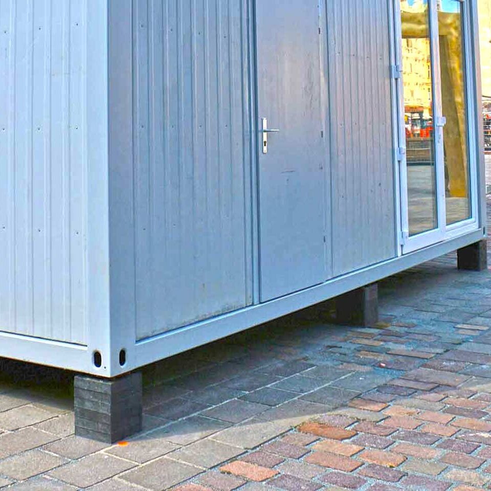 Stapelbarer Unterlegbaustein als Lastverteilplatte aus Kunststoff zur Unterpallung, Isolierung, Niveauausgleich von Containern und fliegenden Bauten