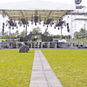 Bodenmatten als Stagemats verlegt auf dem Rasen vor einer Bühne bei einem Open-Air-Event