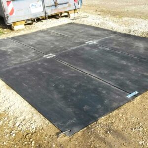 Verlegte Bodenschutzplatten auf Schotter bilden eine ebene, stabile Arbeits- oder Stellfläche auf der Baustelle.