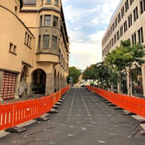 Bodenschutzplatten bilden eine provisorische Fahrbahn zwischen Gebäuden in einer abgesperrten Innenstadtstraße.