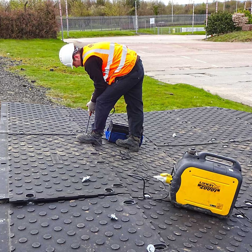 Ein Mann verschraubt die einzelnen MaxiTrack Schwerlastplatten
