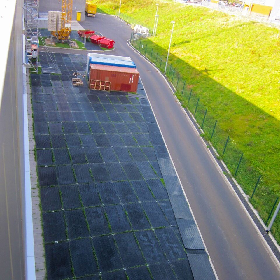 Verlegte Bodenschutzplatten schaffen eine temporäre Lagerfläche neben einer Straße im Industriegebiet.