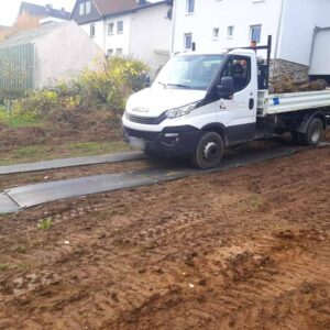 LKW fährt über verlegte Fahrplatten als temporäre Fahrspur auf matschigem Untergrund