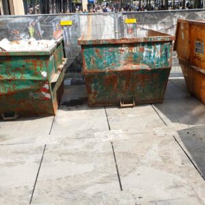 Bauschuttcontainer stehen auf v:tek Fahrplatten zum Schutz des Untergrunds auf der Baustelle