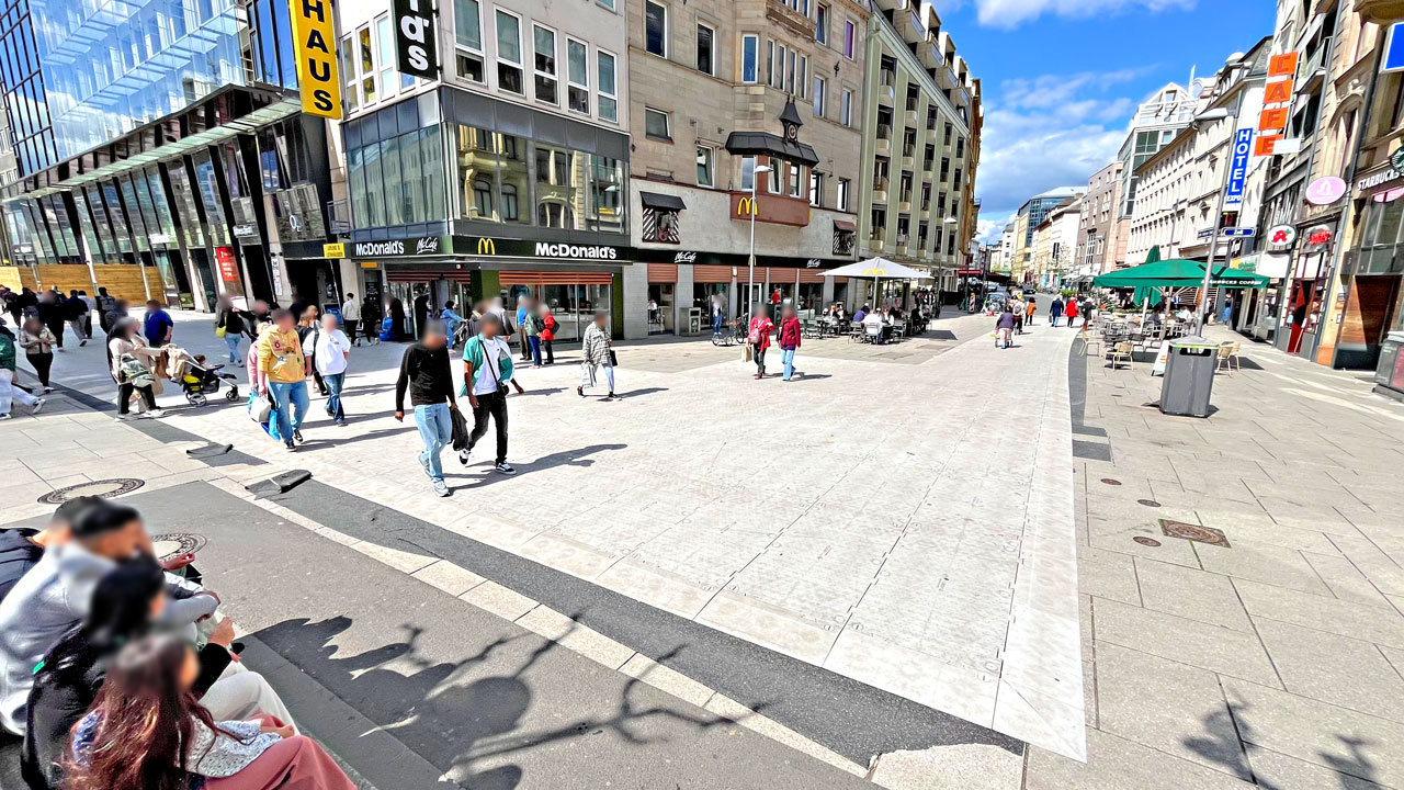 OmniDeck Bodenschutzsystem in einer Fußgängerzone. Es sind verschiedene Geschäfte zu sehen.