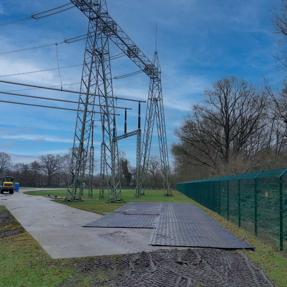 Mit Schwerlastplatte MegaTrack PRO befestigte Arbeitsfläche auf einer Wiese bei einem Umspannwerk.